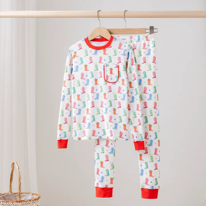 White two-piece pajamas with colorful cowboy boots and stars, a chest pocket, and red neckline, wrist cuffs and ankle cuffs.