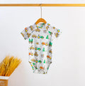 White short-sleeve baby bodysuit with colorful tractors, cows and Christmas trees, hanging on a wooden hanger.