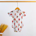 White short-sleeve baby bodysuit with an allover red Santa Claus print and colorful Christmas accents, hanging on a wooden hanger.